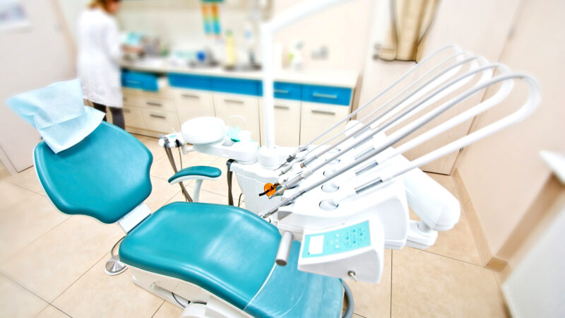 Professional Dentist tools and chair in the dental office. Dental Hygiene and Health conceptual image.